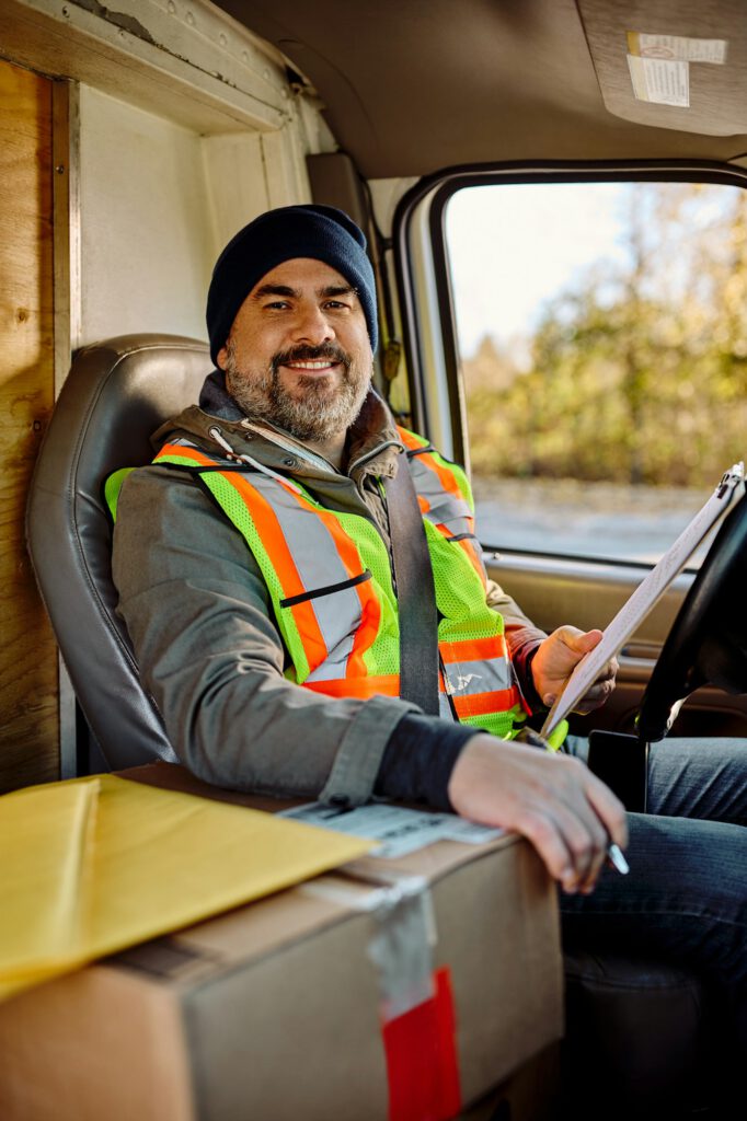 Happy driver in delivery van looking at camera.